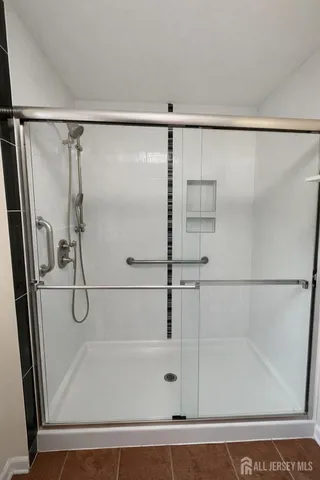a bathroom with a glass shower door and a glass door shower