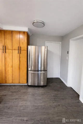 a view of kitchen with stainless steel appliances wooden floor and window