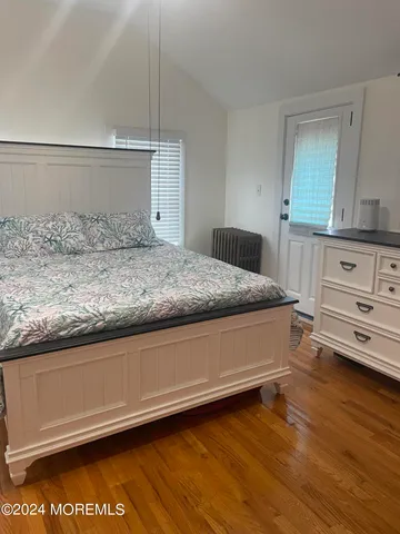 a spacious bedroom with a bed and a dresser