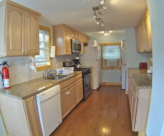 a kitchen with a sink refrigerator and cabinets