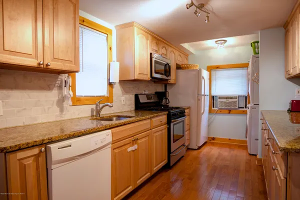 a kitchen with stainless steel appliances granite countertop a sink a stove and a refrigerator