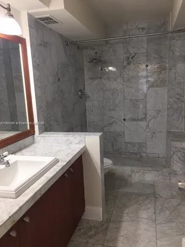 a bathroom with a granite countertop sink a shower and a mirror