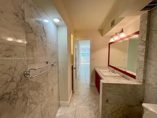 a bathroom with a granite countertop sink and a mirror
