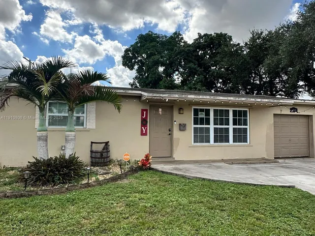 a front view of a house with a garden and plants