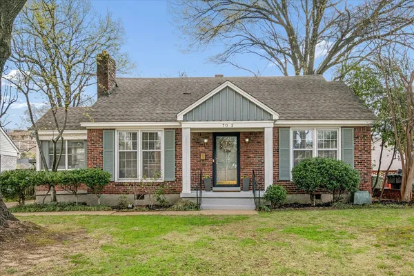 a front view of a house with a yard garden and outdoor seating