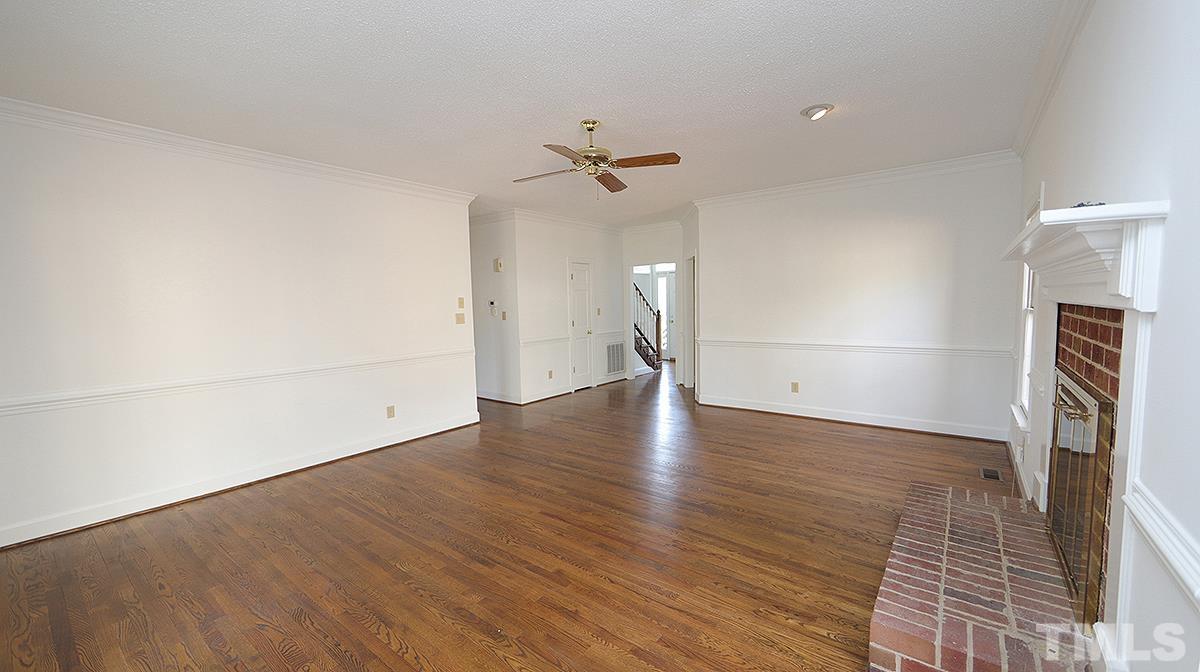 7949 Footman Way Raleigh, NC 27615 - Photo 13 of 28 an empty room with wooden floor ceiling fan and windows