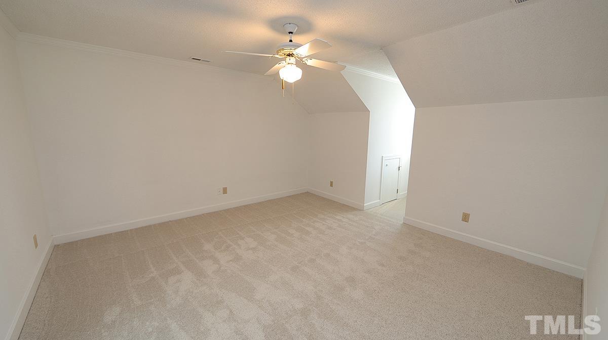 7949 Footman Way Raleigh, NC 27615 - Photo 20 of 28 an empty room with a chandelier fan and windows