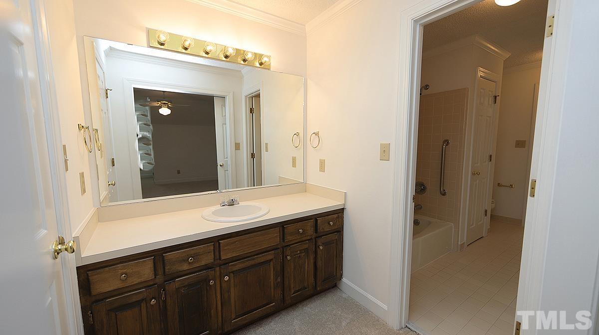 7949 Footman Way Raleigh, NC 27615 - Photo 23 of 28 a spacious bathroom with a sink and a mirror