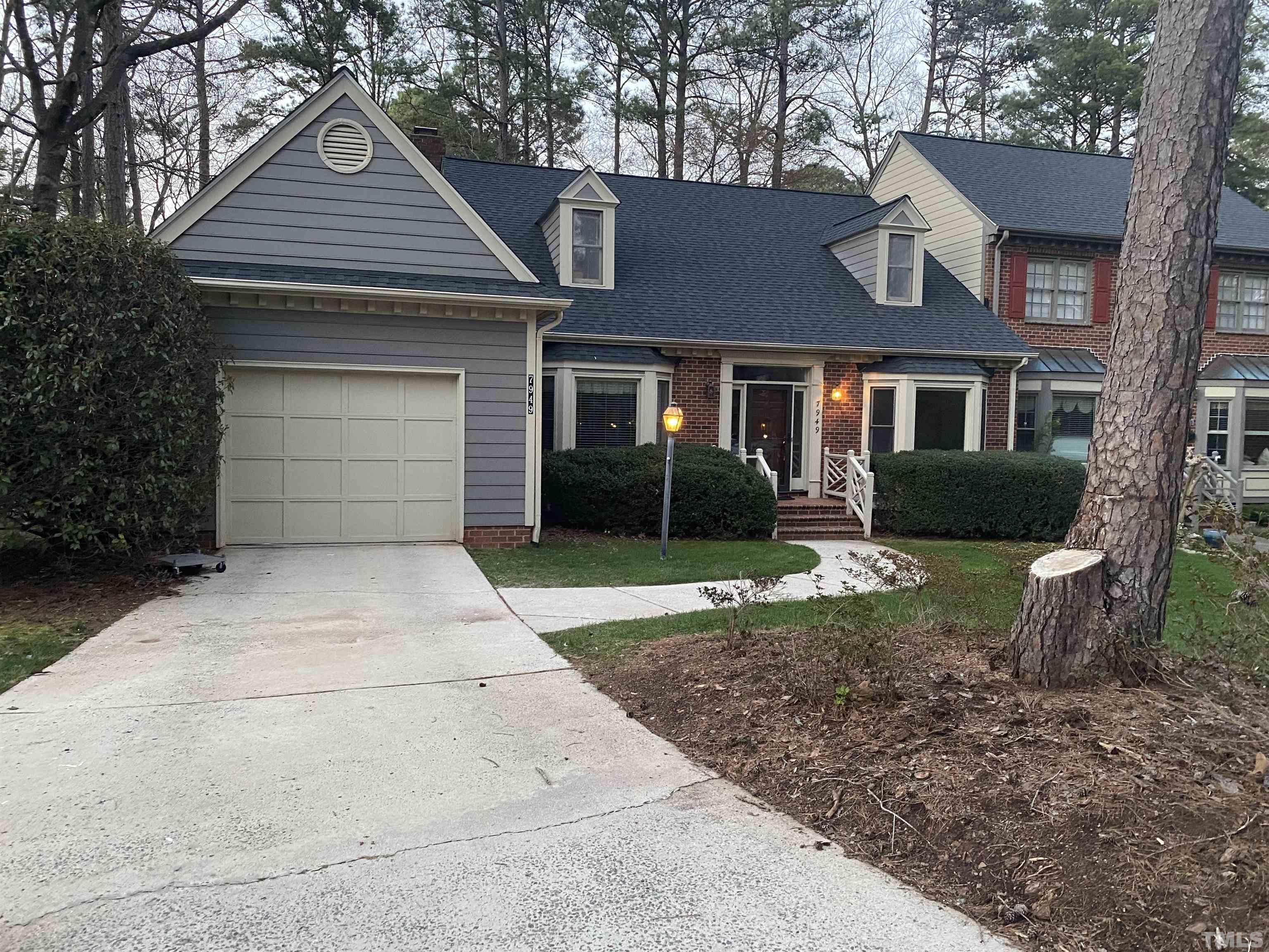 7949 Footman Way Raleigh, NC 27615 - Photo 3 of 28 a front view of a house with a garden and trees