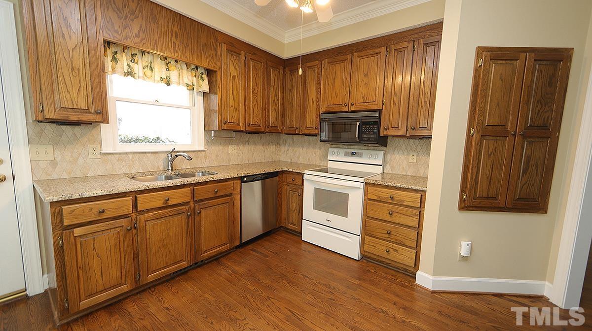 7949 Footman Way Raleigh, NC 27615 - Photo 8 of 28 a kitchen with white cabinets and white appliances