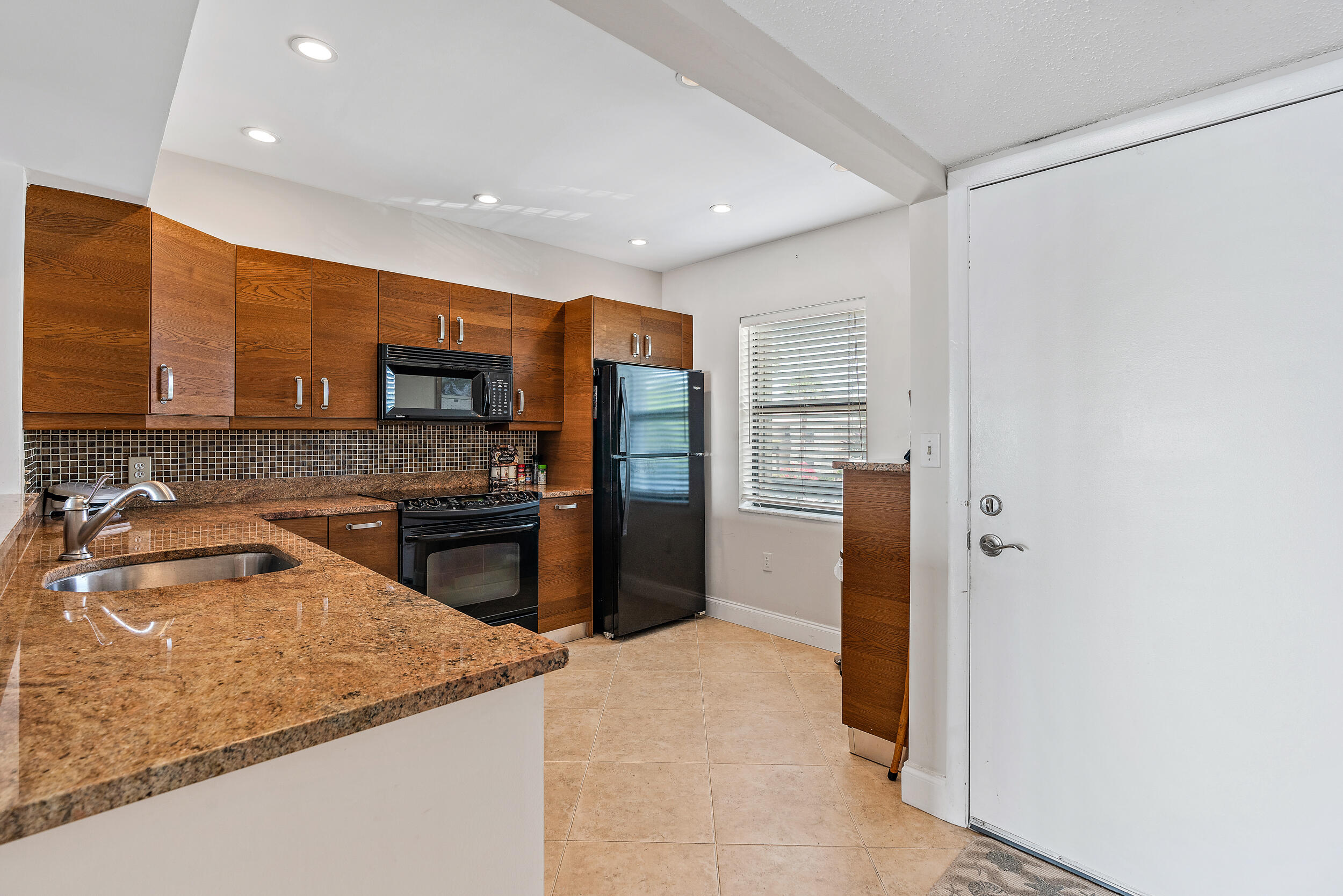1950 Southwest Palm City Road, Unit 1202 Stuart, FL 34994 - Photo 5 of 21 a kitchen with stainless steel appliances granite countertop a refrigerator and a sink