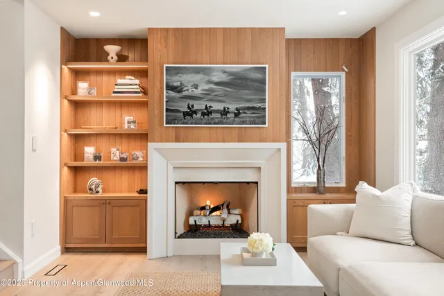 a living room with furniture a fireplace and a large window
