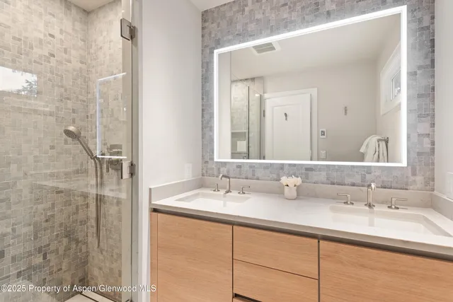a bathroom with a double vanity sink and a mirror