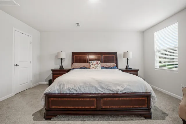 a spacious bedroom with a bed and window
