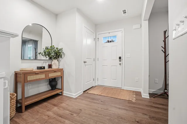 a view of an entryway with wooden floor and mirror