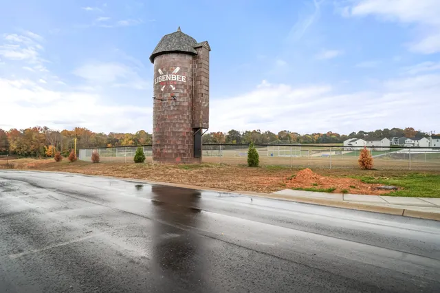 a view of a big house with a big yard and large trees