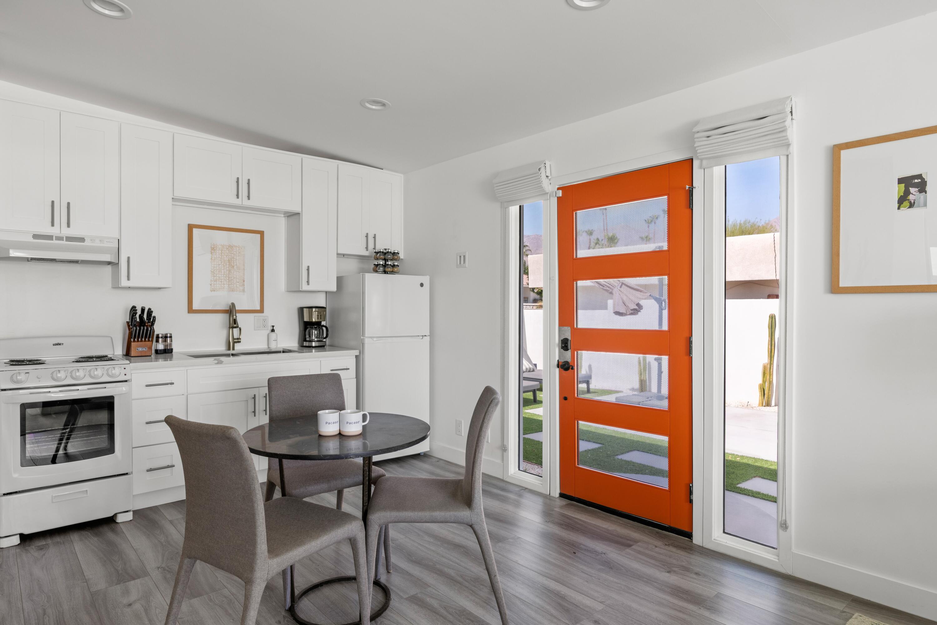 72870 Bel Air Road, Unit 3 Palm Desert, CA 92260 - Photo 8 of 35 a kitchen with stainless steel appliances granite countertop a stove a refrigerator a dining table and chairs with wooden floor