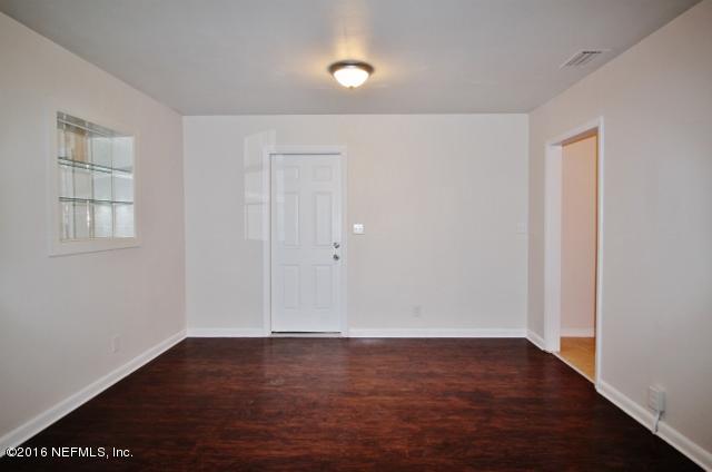 6328 Merrill Road Jacksonville, FL 32277 - Photo 4 of 10 an empty room with wooden floor and windows