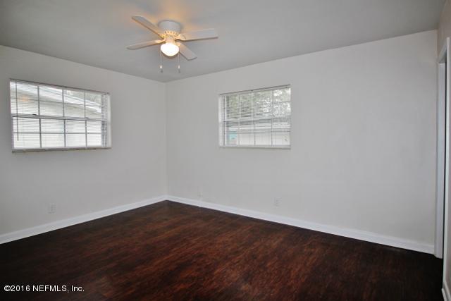 6328 Merrill Road Jacksonville, FL 32277 - Photo 6 of 10 wooden floor in an empty room with a window