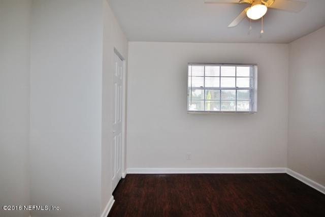 6328 Merrill Road Jacksonville, FL 32277 - Photo 8 of 10 an empty room with wooden floor and windows