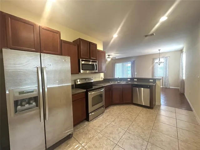 a large kitchen with a large counter top stainless steel appliances and cabinets