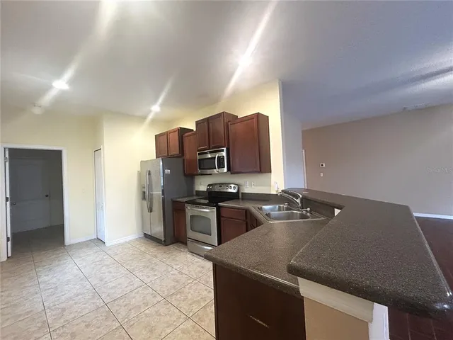 a kitchen with a stove a refrigerator and a sink