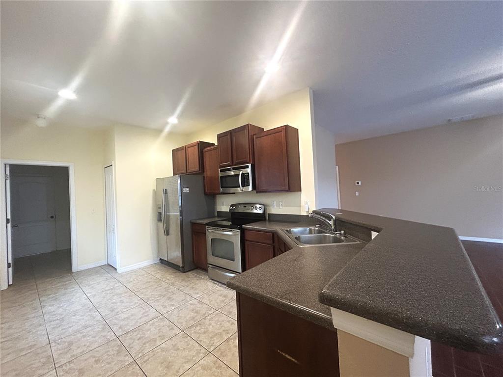 10702 Burning Bush Terrace Land O Lakes, FL 34638 - Photo 12 of 22 a kitchen with a stove a refrigerator and a sink