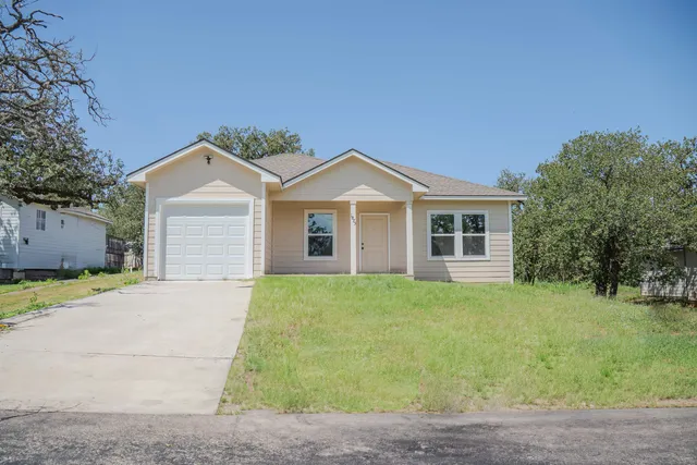a front view of a house with a garden and yard