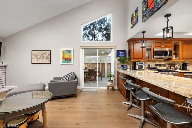 a living room with stainless steel appliances furniture a rug and a window