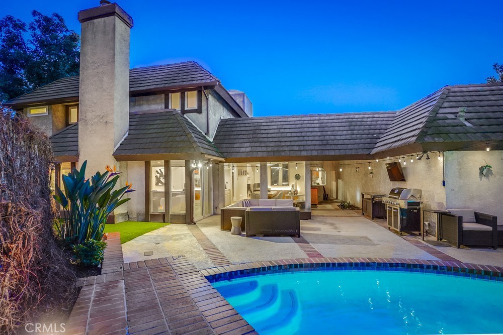 a view of a house with swimming pool and sitting area