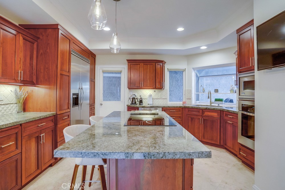 615 Edith Way Long Beach, CA 90807 - Photo 49 of 65 a kitchen with kitchen island granite countertop wooden cabinets a sink and dishwasher