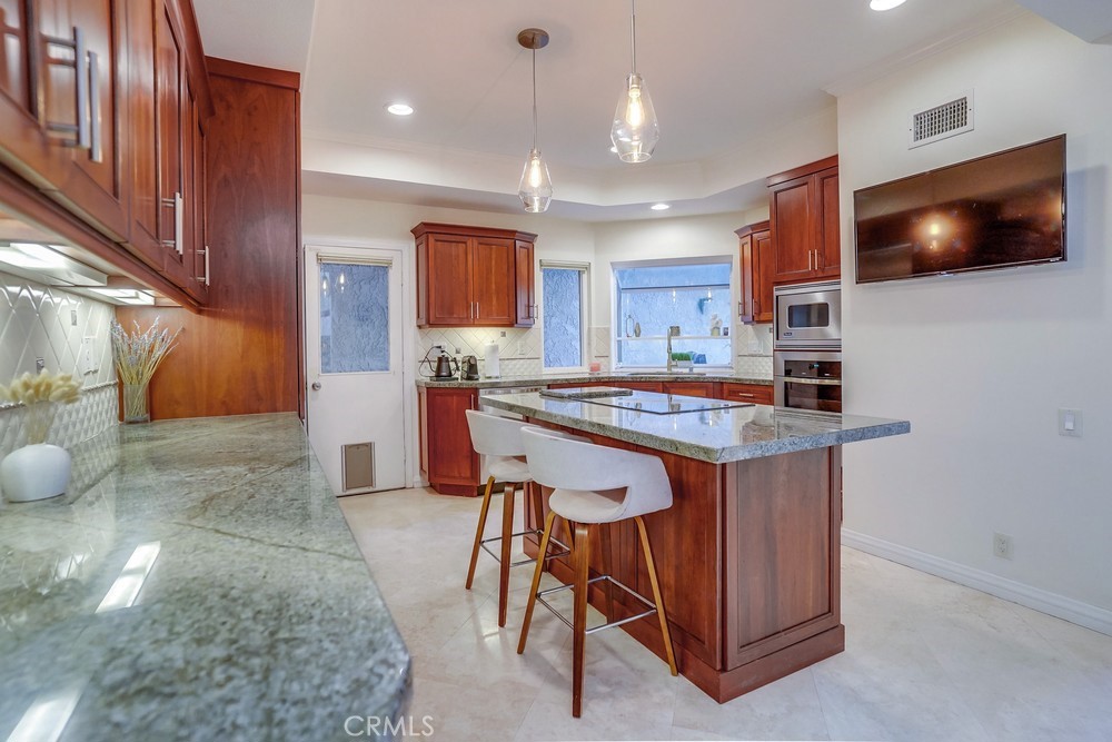 615 Edith Way Long Beach, CA 90807 - Photo 6 of 65 a kitchen with stainless steel appliances kitchen island granite countertop a stove a sink and a microwave