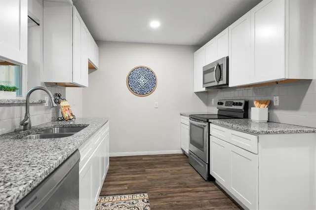 a kitchen with a sink a stove and cabinets