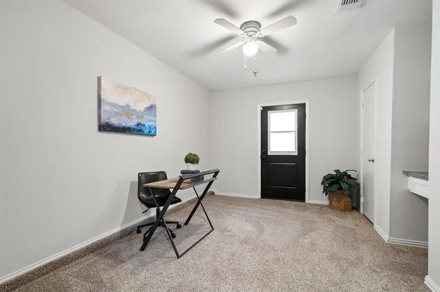 a view of a workspace with furniture and a window