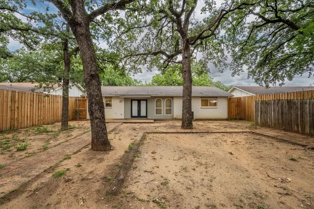 a front view of a house with a large tree