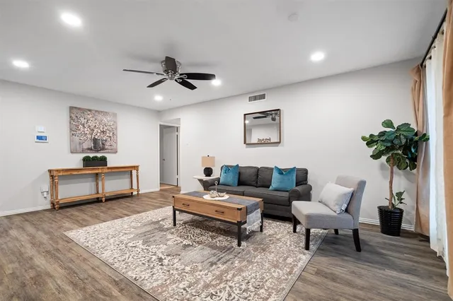a living room with furniture and a wooden floor