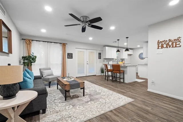 a living room with furniture and a dining table with kitchen view