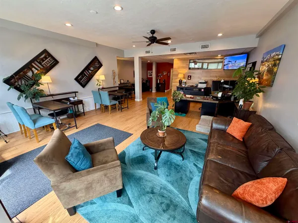 a living room with furniture kitchen and a large window