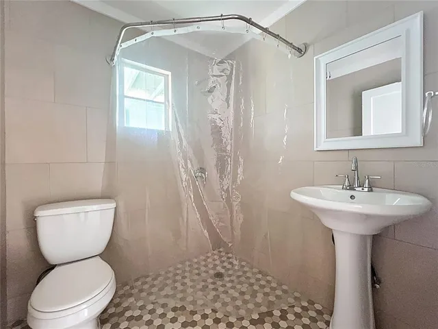 a bathroom with a toilet sink shower and mirror