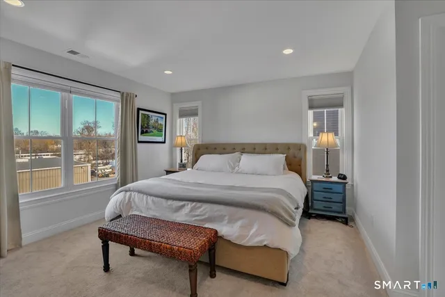 a spacious bedroom with a bed and glass door
