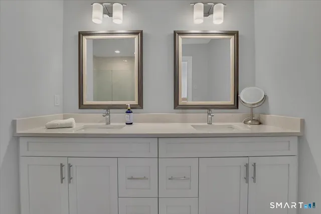 a bathroom with double sink and a mirror