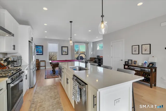 a large kitchen with kitchen island a large counter space a sink appliances and cabinets