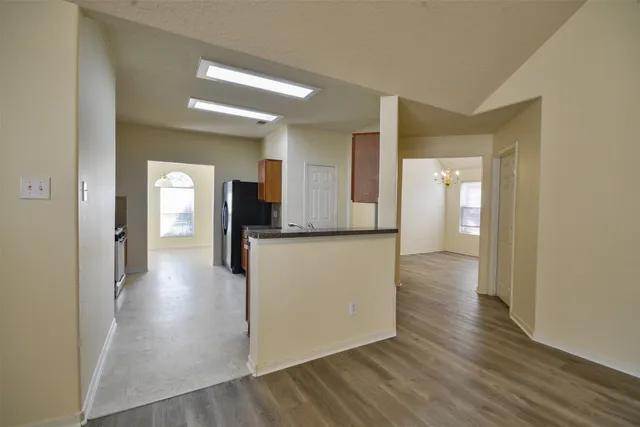 a view of a hallway with wooden floor and a living room