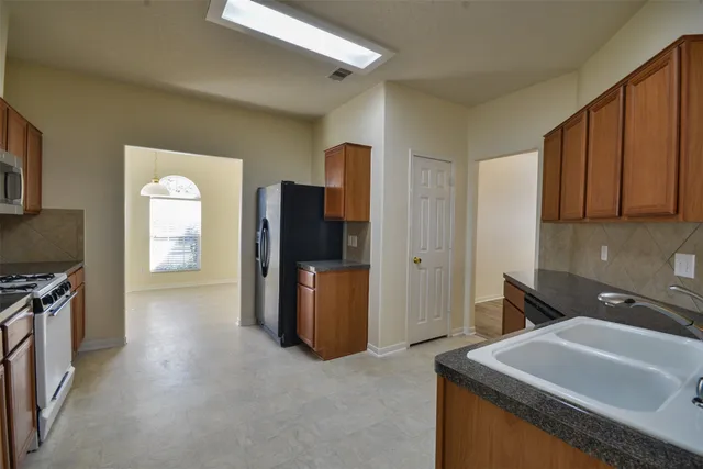 a hallway with a sink and a refrigerator