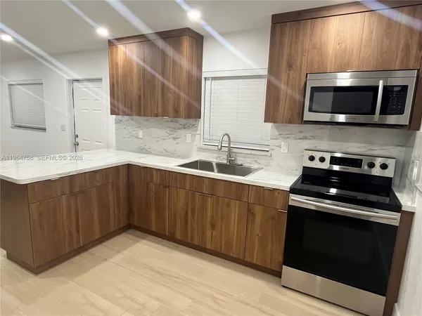 a kitchen that has a sink and a stove in it