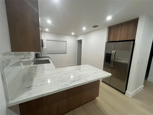 a kitchen with stainless steel appliances granite countertop a refrigerator and a sink