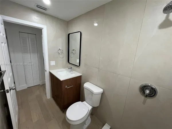a bathroom with a toilet sink a mirror and vanity
