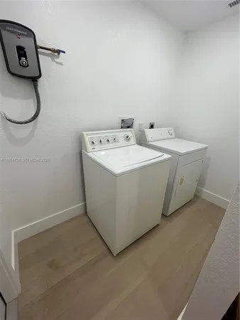 an empty room with wooden floor and entrance