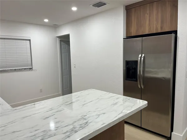 a kitchen with kitchen island a sink and a stove top oven