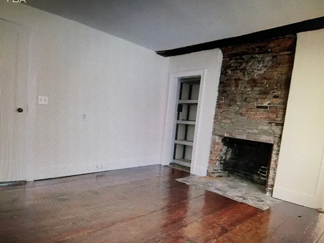 an empty room with windows and fireplace